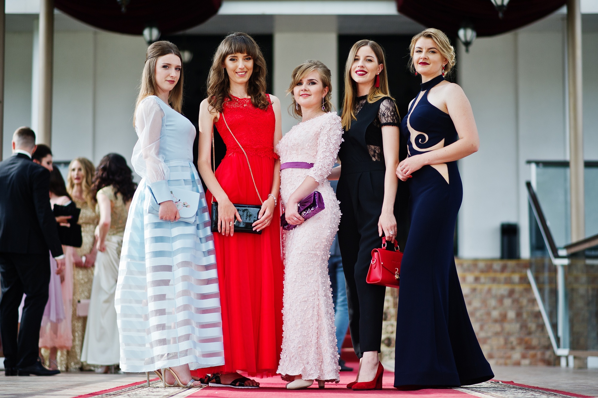 Fantastic young women in awesome fashionable dresses posing in the restaurant.